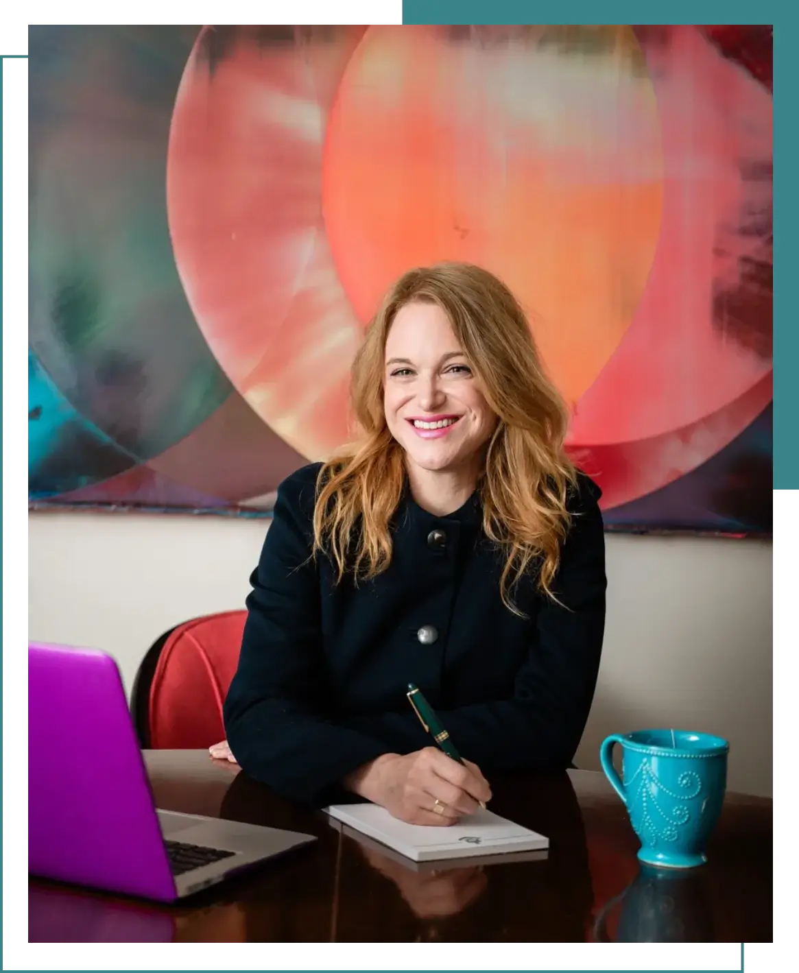 A woman sitting at a table with a laptop and coffee cup.