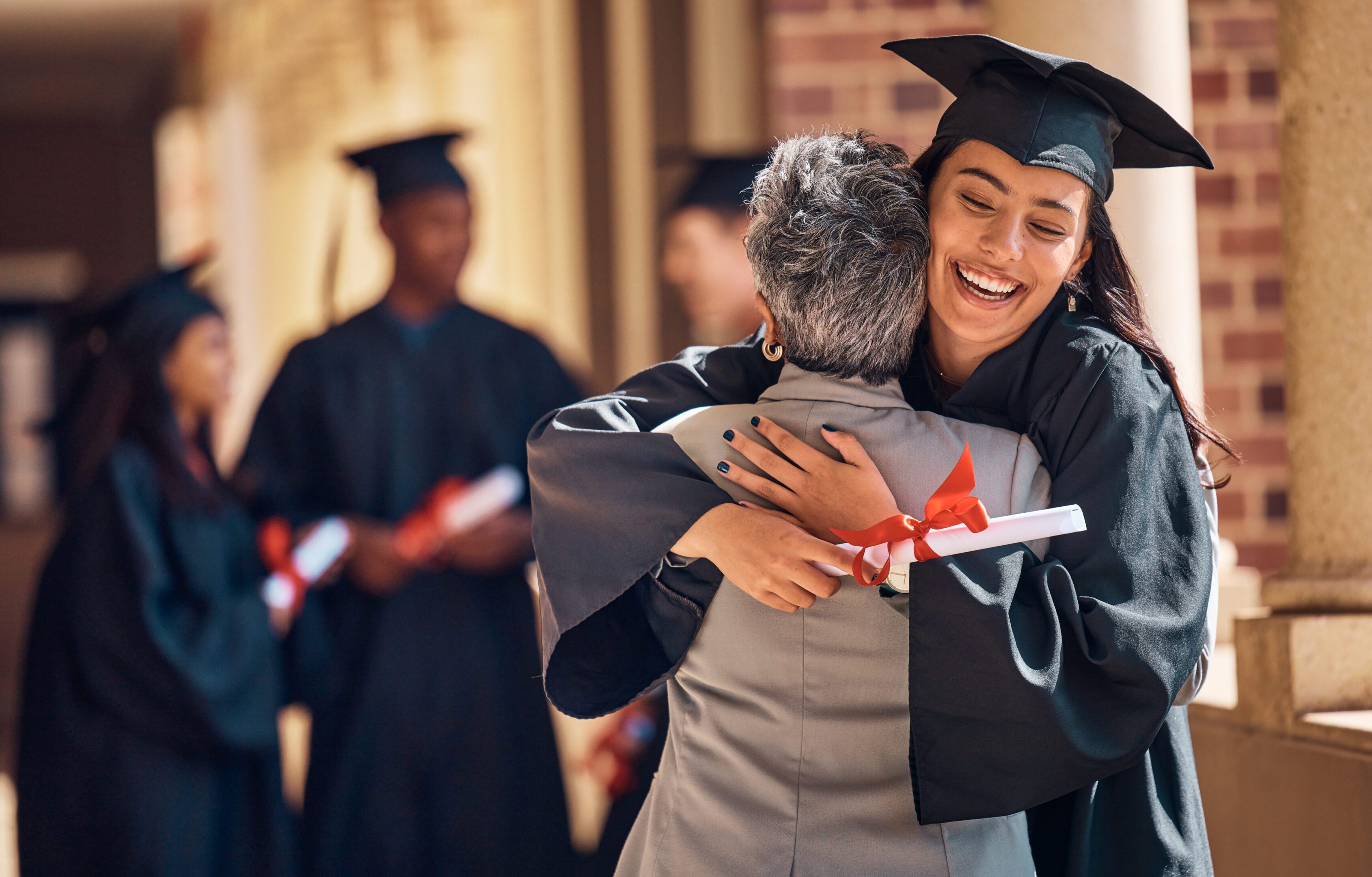 Hug, graduation and graduate, women and education achievement, success on university campus and certificate with academic goals reached. College, student and graduating ceremony, event and degree. Hug, graduation and graduate, women and education achievement, success on university campus and certificate with academic goals reached. College, student and graduating ceremony, event and degree.